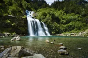 Der Wasserfall fliesst über die Felsstufen runter bis in das natürliche Wasserbecken.