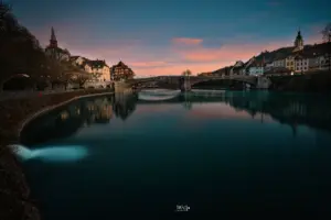 Die blaue Stunde am Rhein bei Laufenburg mit zartrosa Wolken im Hintergrund.