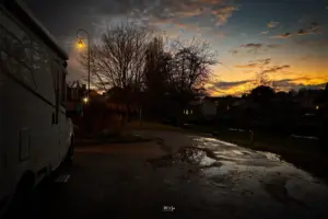 Vom parkierten Wohnmobil aus ist ein Abendhimmel in toller Farbenpracht zu sehen.