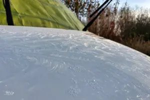 Auf der gefrorenen Motorhaube sind lauter Eisblumen zu sehen.