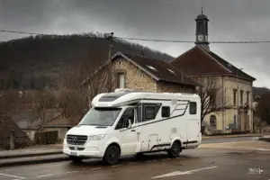 Wohnmobil steht auf dem Parkplatz in einem Dorf.