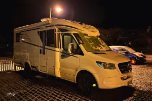 Auf einem Parkplatz steht ein Wohnmobil parkiert.