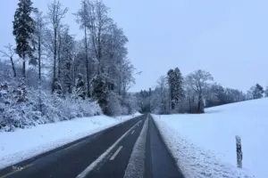 Eine Strasse führt durch die verschneite Landschaft.
