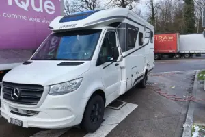 Wohnmobil steht auf einem Rastplatz an der Entsorgungsstelle um Wasser zu tanken und das Abwasser zu entleeren.