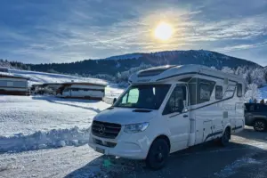 Wohnmobil steht in der verschneiten Landschaft.