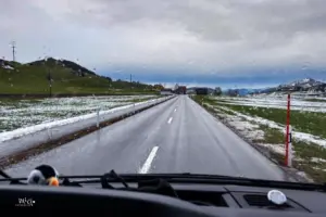Sicht aus dem Cockpit eines Autos auf die vorausliegende Strasse bei Regenwetter.