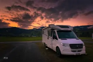 Wohnmobil steht auf dem Parkplatz bei toller Abendstimmung.