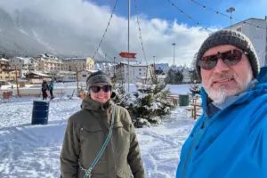 Zwei Menschen stehen im Schnee auf einem grossen Platz.