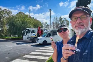 Zwei Personen geniessen vor dem Wohnmobil eine Glacé.