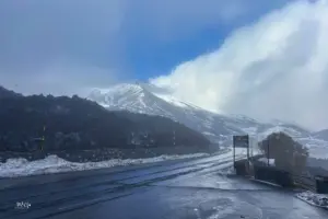 Der dichte Nebel reisst für einen kurzen Augenblick auf und gibt den Blick auf den verschneiten Vulkan Ätna frei.