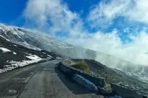 Strasse führt unter den Berggipfeln durch Nebelschwaden hindurch.