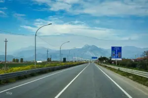 Die Strasse führt in einer langen Gerade voraus als würde diese direkt in die Berge führen.