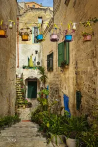 Der Hauszugang zu einem Altstadthaus in Matera ist geschmückt mit farbigen Keramiktöpfen die über dem Durchgang aufgehängt sind.