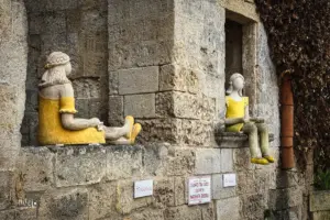 Zwei grosse Keramikfiguren sitzen auf den Fenstersimsen des Hauses.