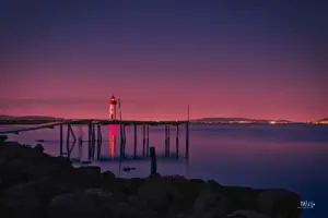 Eine farbenfrohe Abendstimmung gibt dem Lagunensee eine wundervolle Stimmung mit dem Leuchtturm im Hintergrund.