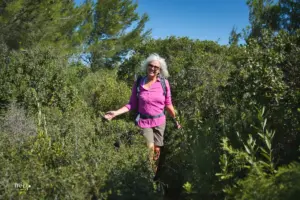 Ein Frau beim wandern mitten in den Bäumen.