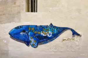 Bunter Walfisch als Kunstwerk an einer Hausfassade.