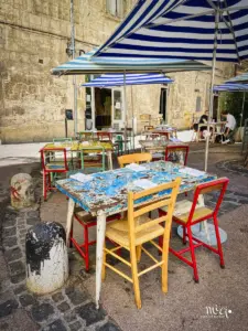 Kleines Bistro in einer Seitengasse in der Altstadt von Montpellier mit bunt zusammengewürfeltem Mobiliar. Jeder Stuhl ist anders und hat eine andere Farbe, ebenso die Tische.