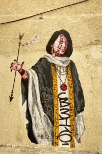 Fassadenmalerei zeigt eine asiatische Frau mit einem Pfeil der die Hand durchbohrt hat.