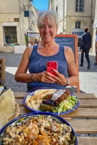 Die Frau freut sich auf ein feines Essen in einem Strassenrestaurant mitten in Montpellier.