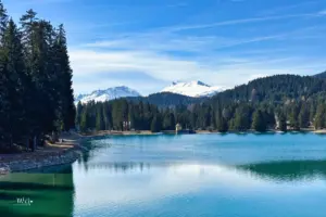 Der Heidsee in Lenzerheide mit der verschneiten Bergkulisse im Hintergrund.