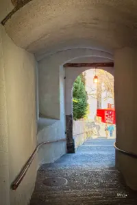 Steil führt die Fussgängerpassage durch einen Bogendurchgang in die Stadt hinunter.