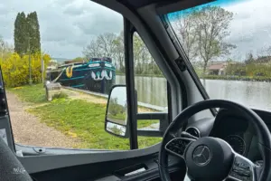 Der Blick aus dem Wohnmobil fällt auf den vorbeiführenden Kanal mit dem grossen Schiff das am Ufer angelegt hat.