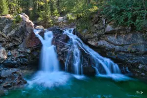 Ungestüm rauscht das Wasser über die dunklen Felsen in das unten liegende Felsbecken.
