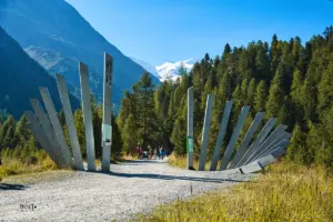 Kunstwerk aus Pfählen markieren den Eingang zur Wanderung zum Morteratsch Gletscher.