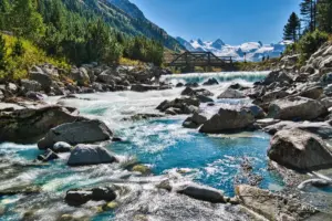 Der Fluss ist das Schmelzwasser vom Morteratsch Gletscher. Ganz hinten sieht man das Bernina-Bergmassiv.
