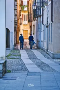 Zwei Menschen schlendern durch die Altstadtgassen von Orta San Giulio.