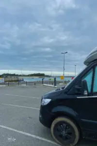 Auf dem leeren Parkplatz im Hafen von Le Croisic steht ein Wohnmobil.