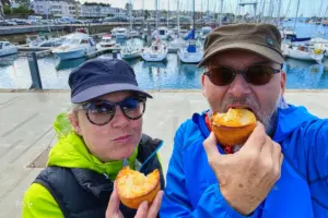 Eine Frau und ein Mann sind am geniessen des feinen bretonischen Süssgebäckes Kouign Amann