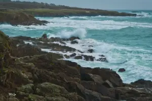 Aufgewühlt vom heftigen Wind peitschen die Wellen an die Felsen der Küste.