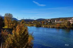 Vom Ort Millau aus blickt man über den Fluss Tarn zum Viaduc de Millau welches die ganze Talsohle in der Höhe überspannt. Das Bauwerk ist ein Teil der A75 und ermöglicht es direkt, ohne wie zuvor durch das Tal zu queren, oben drüber den Ort Millau zu "überfahren".