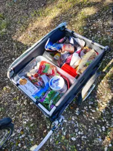 Der Fahrradanhänger ist nach dem Grosseinkauf prall gefüllt mit Lebensmitteln.