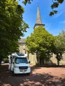 Ein Wohnmobil steht auf dem direkt vor der Kirche deklarierten Stellplatz in Chalandray.