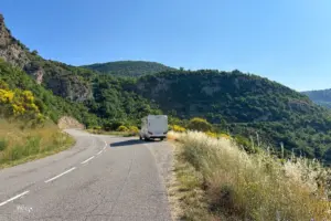 Auf der Bergstrasse steht am Strasssenrand ein parkiertes Wohnmobil.