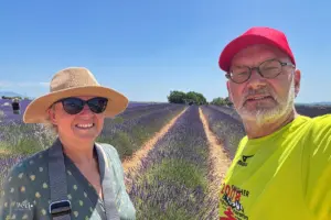Eine Frau und ein Mann stehen am Rande eines Lavendelfeldes und machen ein Selfie.
