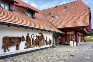 Der Eingang der Schaukäserei in Affoltern im Emmental ist durch die Fassaden Dekoration mit grossen Holzfiguren sofort erkennbar.