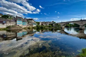 Spiegelglatt ist das Wasser der Dordogne wo sich die Häuser und der Himmel spiegeln im Wasser.